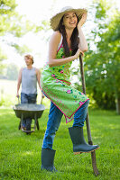 Young woman with foot on a spade