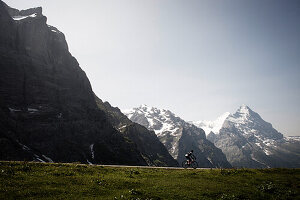 Cyclist on a mountain pass, Eiger and Moench in the background, descent from Grosse Scheidegg to Grindelwald, Bernese Oberland, Switzerland