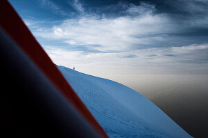 Mountaineer on glaciate mountain ridge, View from a tent, Mont Blanc Mountain Massif, Graian Alps, France