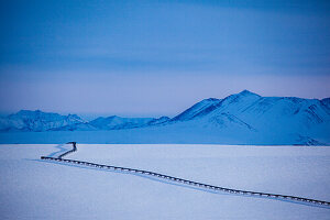 Transalaska Öl-Pipeline im Winter mit Sonnenuntergang in der Brookskette, North Slope Borough, Alaska, USA