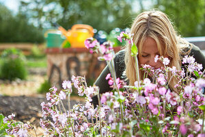 woman inhaling at fresh herbs in a garden
