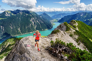 Trailläuferin läuft auf Grat zwischen Seekarspitze und Seebergspitze am Achensee, Tirol, Österreich