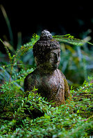 Bhudda-Statue aus Stein in einem grünen Garten, Bali, Indonesien, Asien