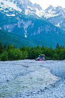 Albania, Southern Europe, young couple in front of off-road vehicle with roof tent, Albanian Alps, Valbona