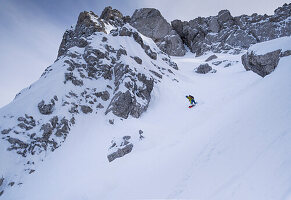 Snowboarder with a splitboard on the descent of the Eppzirler Scharte rock gully on a ski tour in the Karwendel