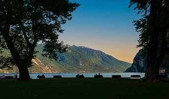 Menschen warten auf den Sonnenuntergang am Ufer des Gardasee in Riva del Garda. Trient. Italien