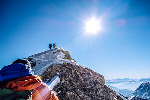 Mountain guide with customer during the winter ascent of the Jubilee Ridge, from the Zugspitze to the Alpspitze in the Wetterstein Mountains, Bavaria, Germany