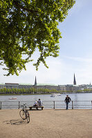 People look out over the Binnenalster, Alster Lake, in Hamburg, Germany