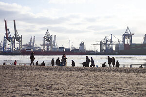 People on the Elbe beach at the container port, Hamburg, Germany