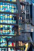 Alter Lastkran vor Glasfassade Bürogebäude, darin spiegelt sich das Hochhaus Colorium, Fassade mit farbigen Glaspaneelen, Architekt William Alsop, Julo-Levin-Ufer im Medienhafen, Düsseldorf, Nordrhein-Westfalen, Deutschland, Europa