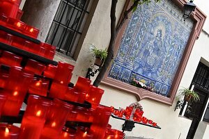 Kerzen und kleine Andachtsstätte vor einer kleinen Kirche in Sevilla, Andalusien, Spanien