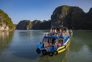  Excursion boat Hoang Long 21 arriving at Cat Be Island with karst islands behind, Lan Ha Bay, Haiphong, Vietnam, Asia 