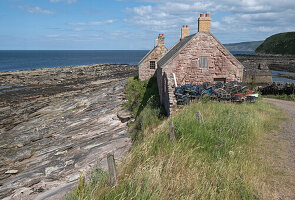  View of an old stone house in an old harbour at low tide, East Lothian, Scotland, United Kingdom 