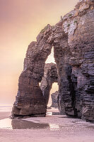 Felsbogen im Abendrot am Sandstrand von Playa de las Catedralas bei Sonnenuntergang, Gemeinde Ribadeo, Provinz Lugo, Galicien, Nordspanien, Spanien