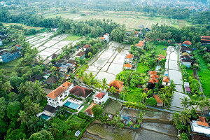  Luftaufnahme von überfluteten Reisfeldern und Landhäusern in Ubud, Bali, Indonesien. 