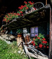 Dekorativer Blumenschmuck und Holzschmuck vor einer Alphütte in Mürren, bei Lauterbrunnen, Berner Oberland, Schweiz