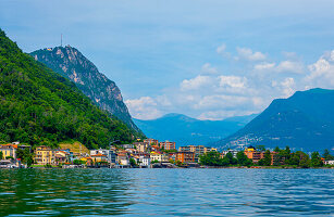 Elegantes Haus am Berghang an einem sonnigen Sommertag am Ufer, Luganersee in Melide, Lugano, Tessin, Schweiz.