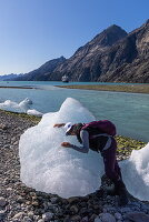 Frau umarmt Eisbrocken von Gletscher, Ikamiut Kangerdluarssuat, Queqatta, Grönland, Europa