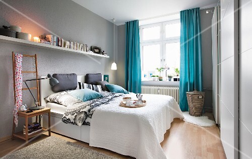 A Bedroom With Light Grey Walls And Blue Curtains With A Long