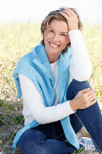 A Mature Woman With Short Blonde Hair In The Countryside Wearing